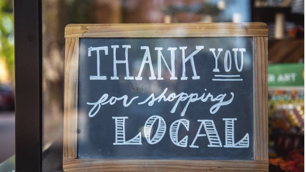 A sign on a door saying thank you for shopping local